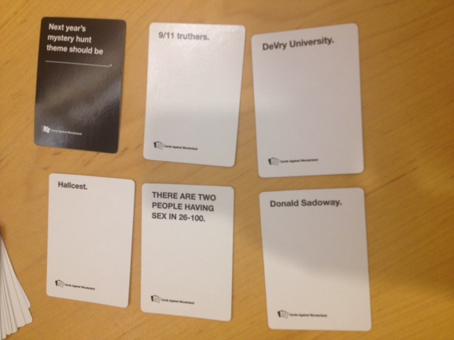 Two people playing cards against humanity. You draw cards for two players,  plus a hand for a invisible player to be picked at random, so three white  cards total per hand. Once