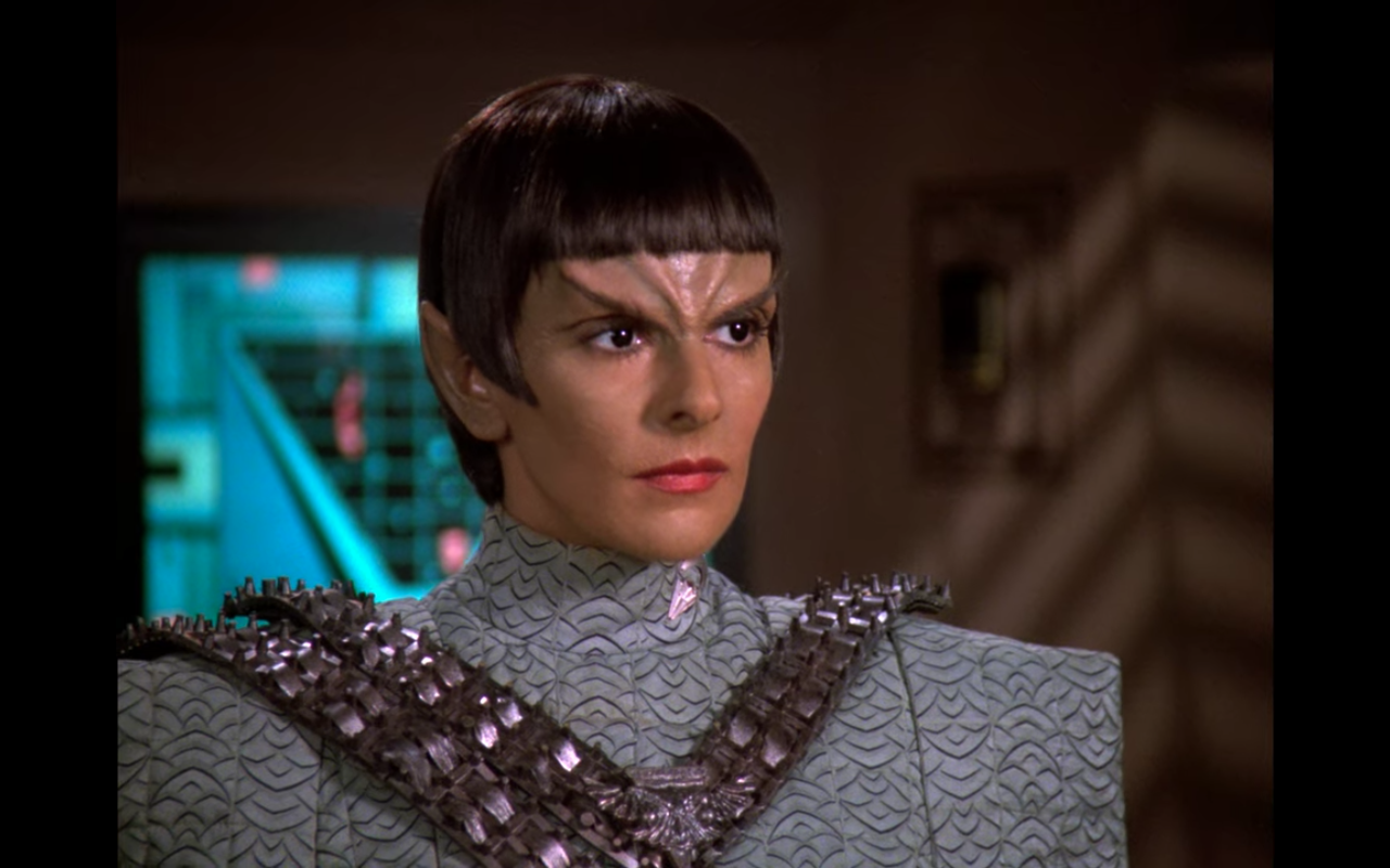 Troi, dressed as and looking like a Romulan
