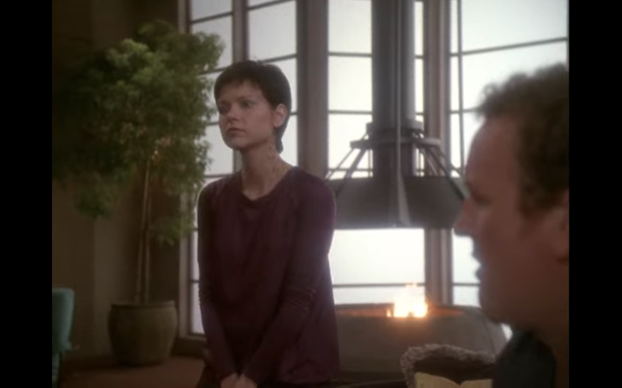 Miles and Ezri, out of uniform, in a living room with a fire pit