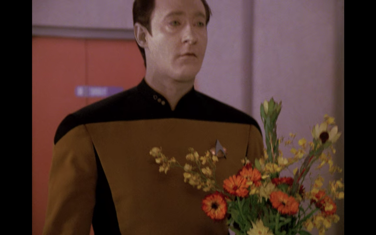 Data, carrying a bouquet of flowers