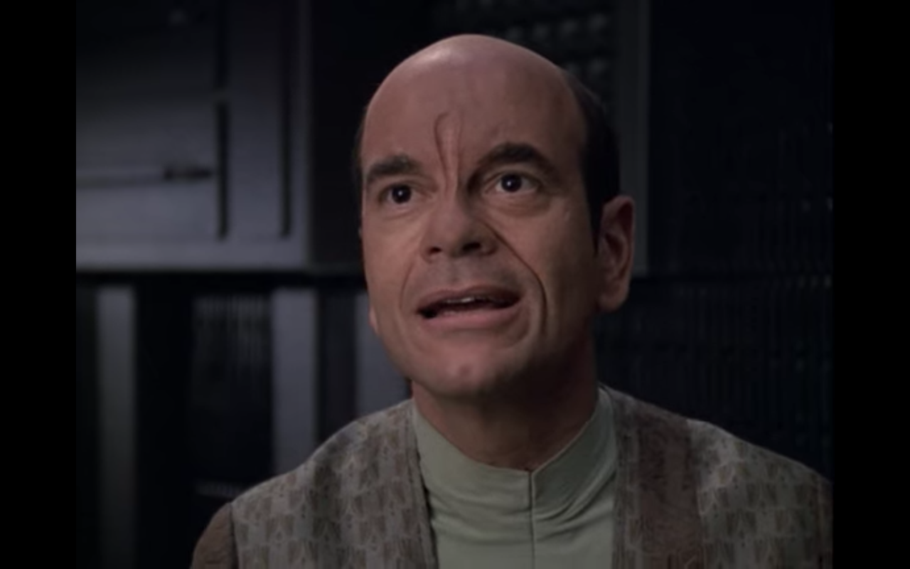 Voyager's doctor in alien clothes and an alien forehead