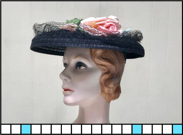 A female mannequin wearing a flat cap with a flower on top. 18 blanks with 3, 14, 18 highlighted.